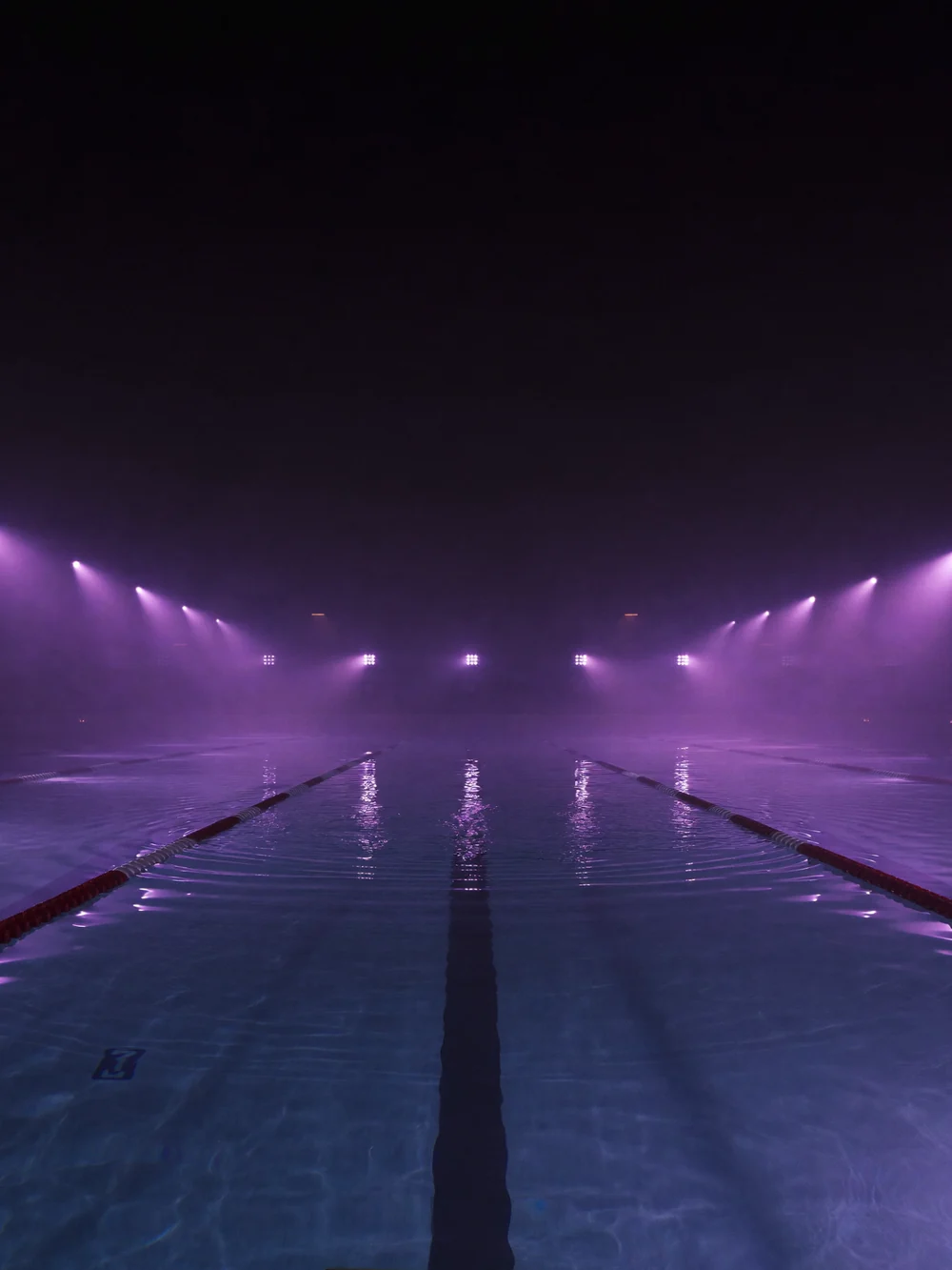 Piscina coberta com raias iluminada em violeta