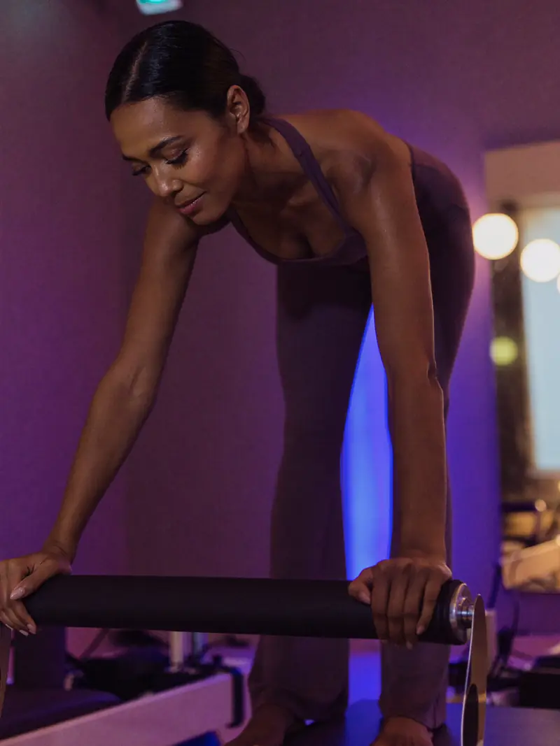 Mulher praticando pilates em um estúdio.